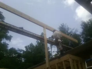 Carpenter setting a ridge beam over a new addition frame — Ice Dam Removal by Roofing Brothers in Vinegar Bend