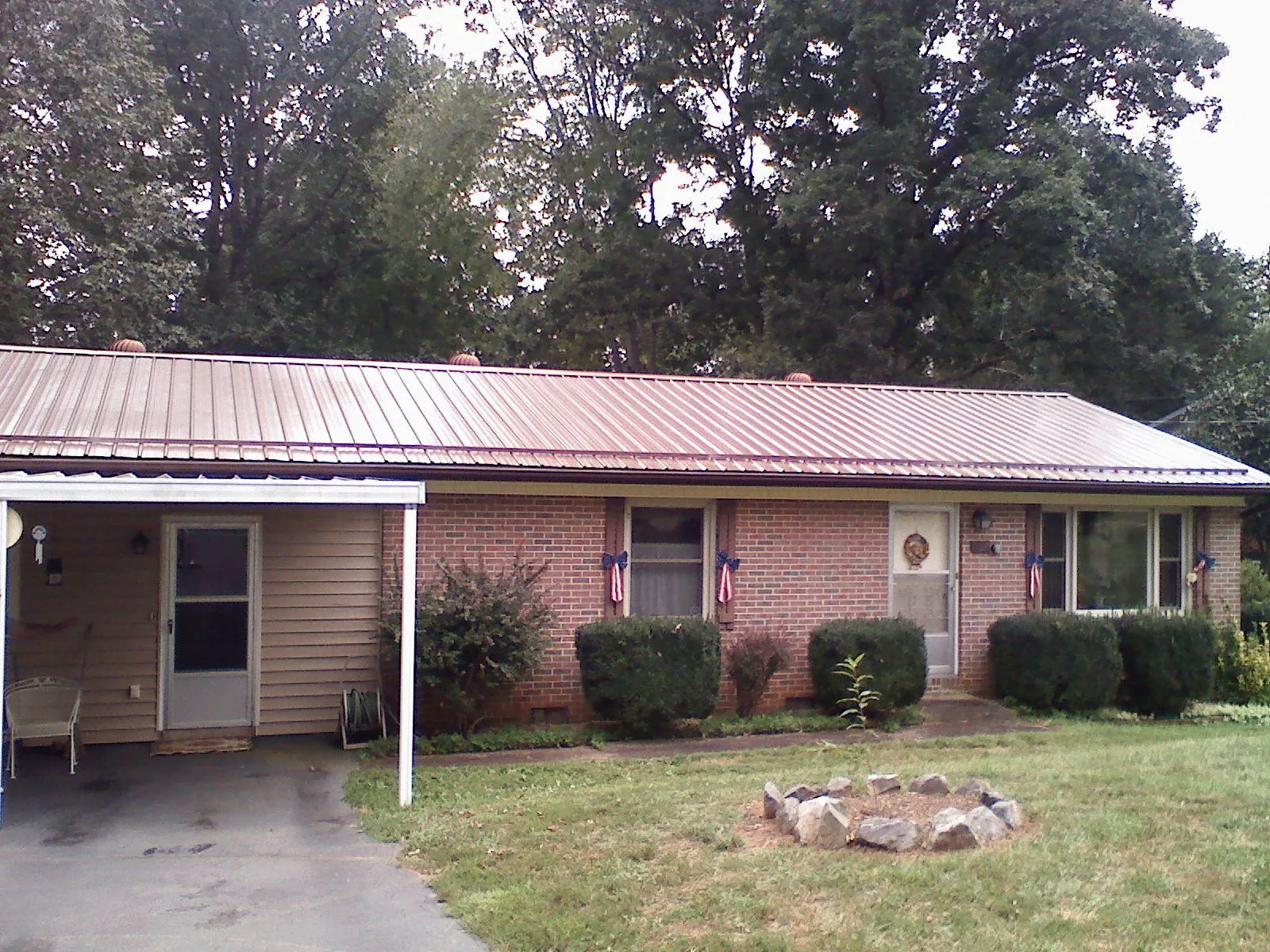 Bronze metal roof and carport on a brick ranch home — Roof Repair work by our crew in Vinegar Bend