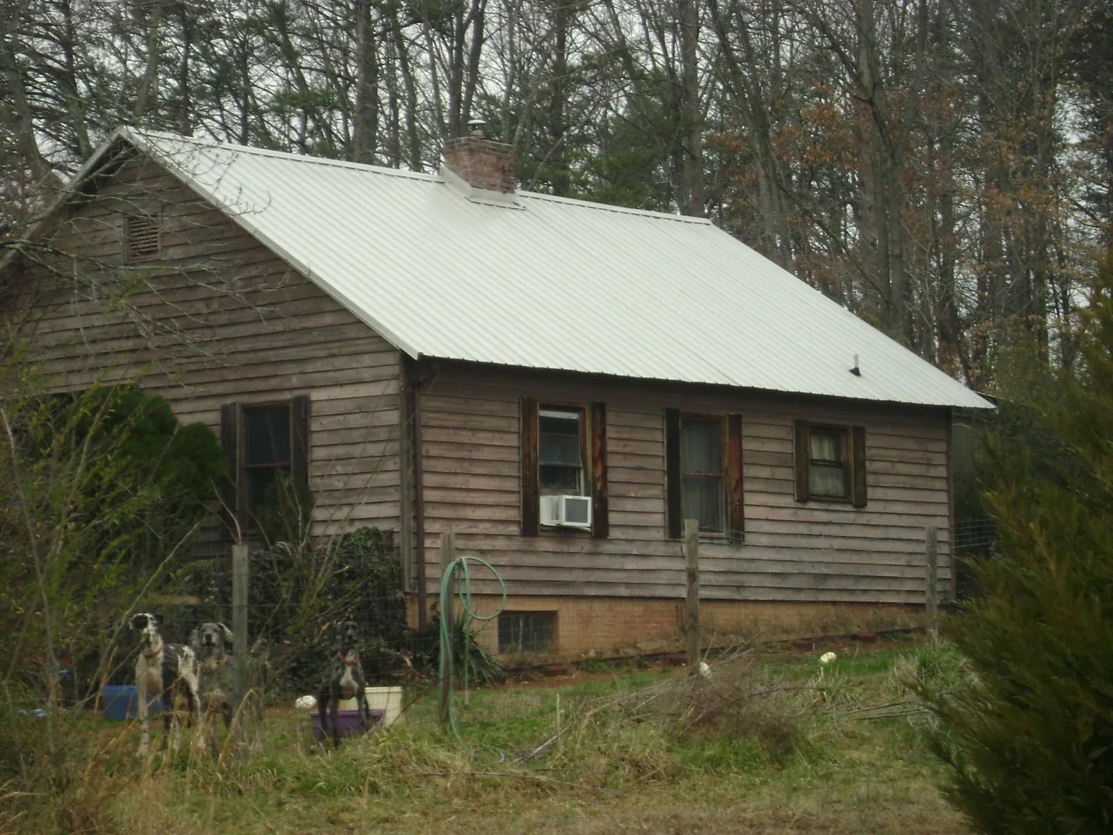 White metal roof on an old wood sided farmhouse, from a Metal Roof Installation job in Vinegar Bend